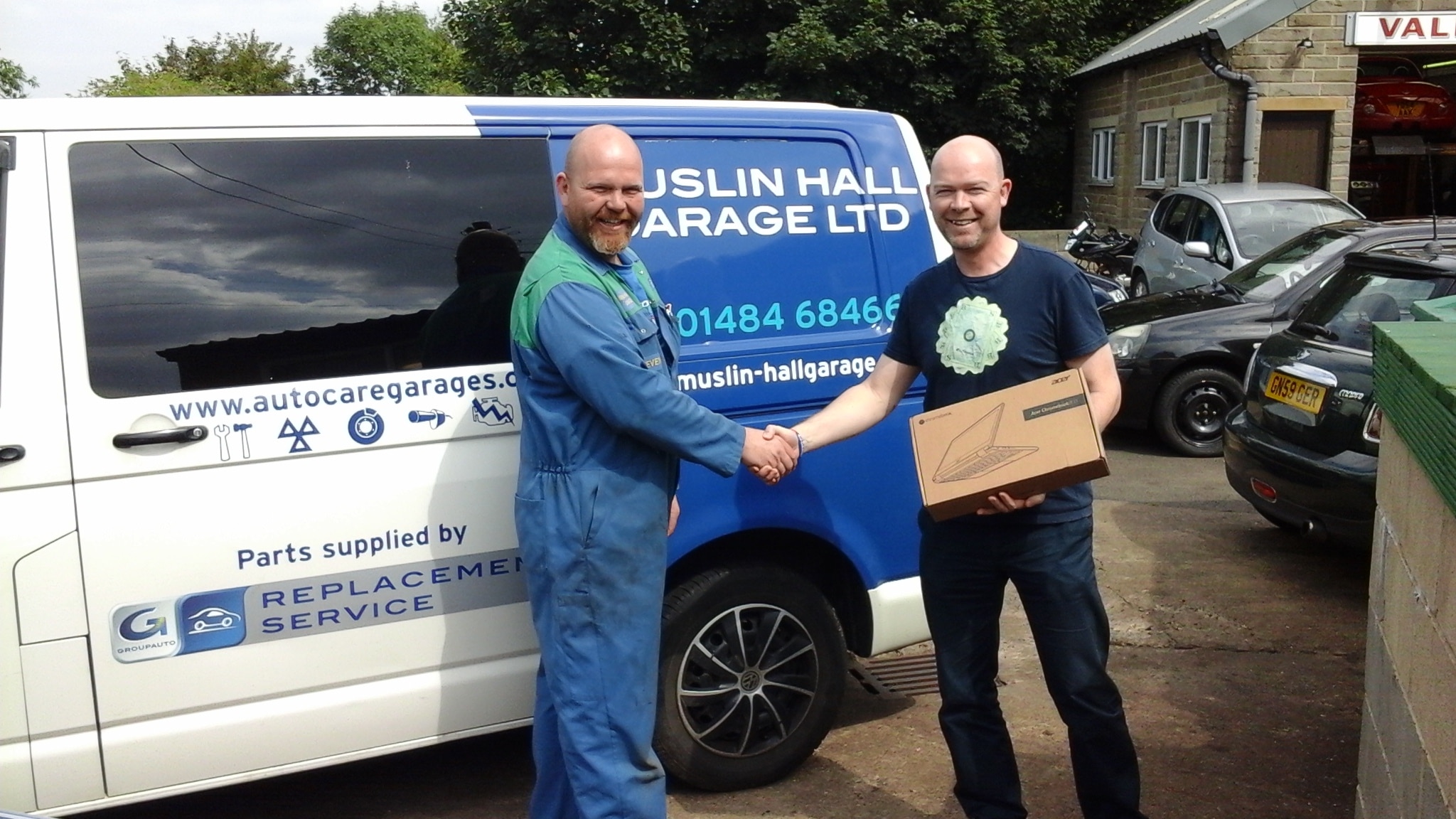 Our Auto Care Garages Summer Giveaway winner 2016 - Russell Briggs being presented with his laptop computer prize by Steven Parr of Muslin Hall Garage 